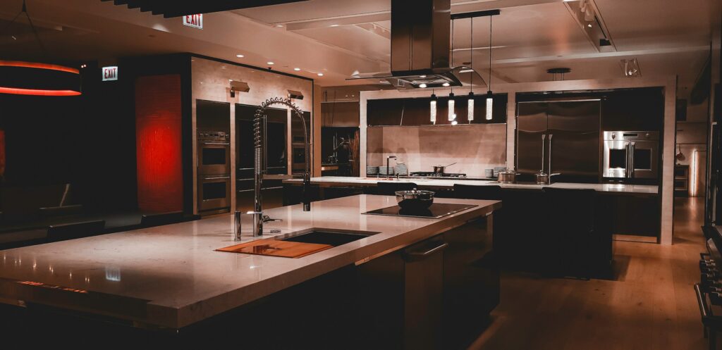Modern luxury kitchen with a center island, white cabinetry, and stainless steel appliances, showcasing a bright and elegant design.