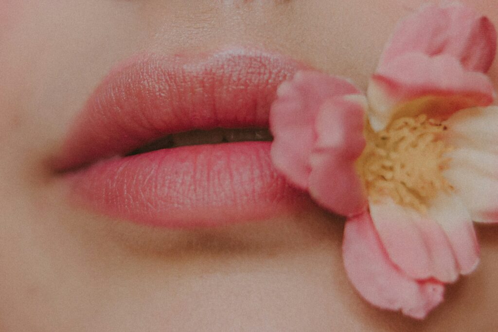 A close up of a woman's lips with a flower