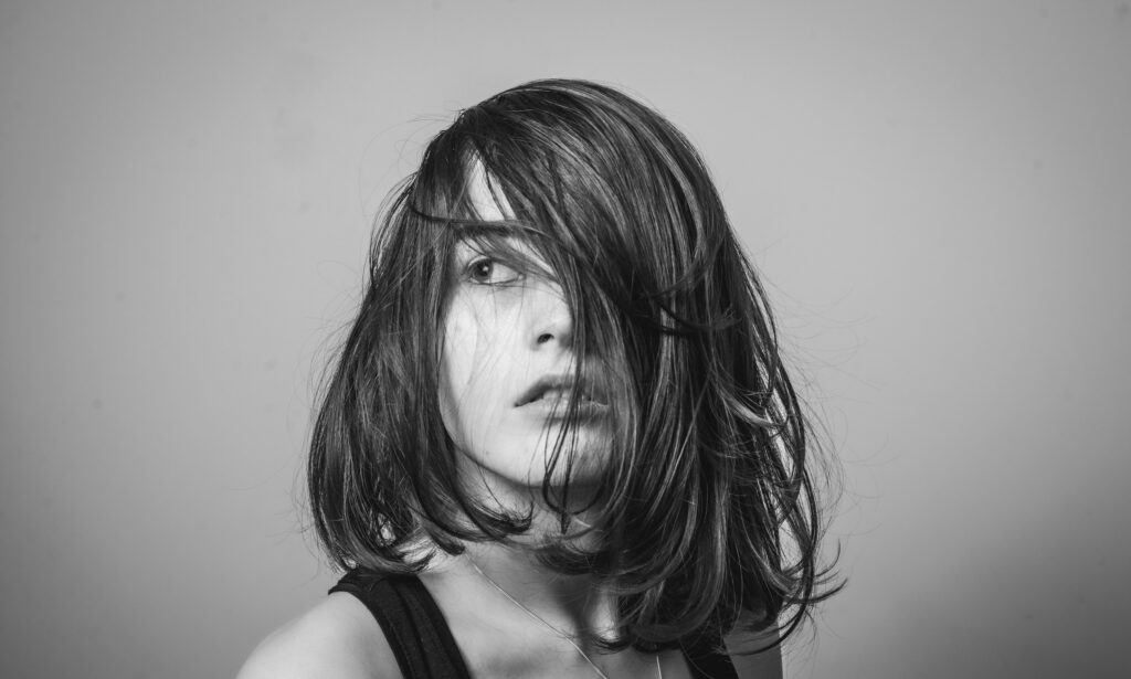 Black and white photo of a woman with her hair blowing in the air