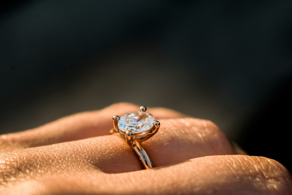 Close-up of a hand holding a marquise diamond ring, showcasing the vintage cut and elegant setting.