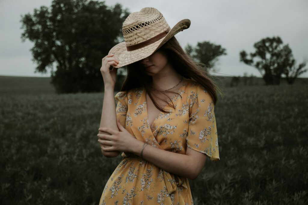 A woman in floral dress standing in a field 