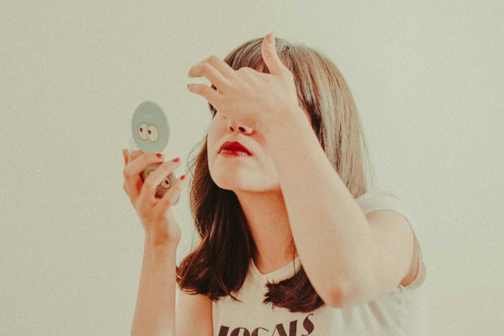 A girl holding mirror to her face