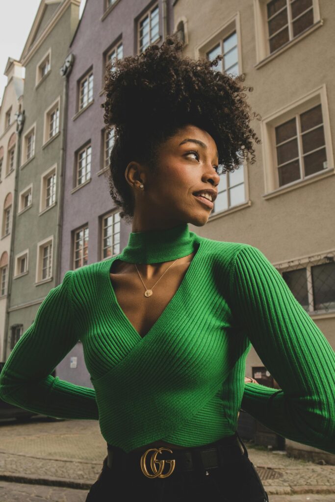 A woman wearing green top and coily hair