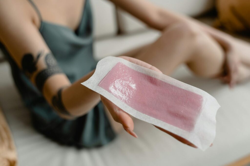 A woman holding a wat wax patch.