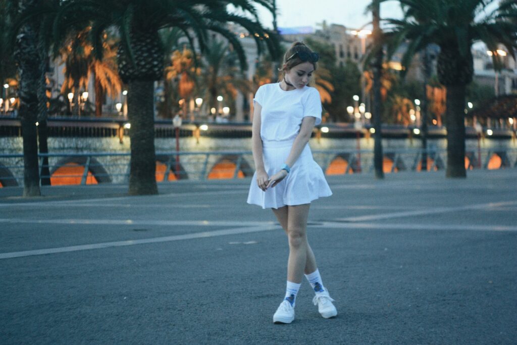 Woman wearing a white structured skirt and tucked-in blouse, showcasing a minimalist take on the bubble skirt trend for 2025.