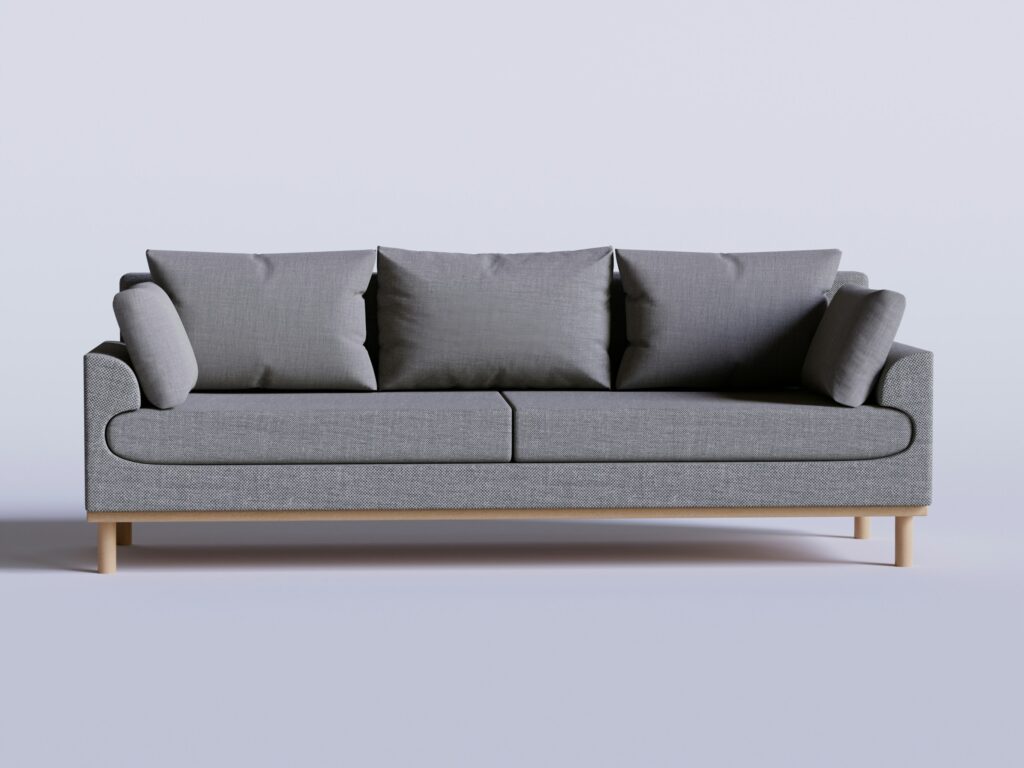 French country sofa styled with four pillows in a cozy neutral living room.