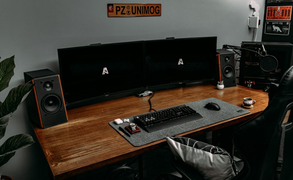 Minimalist home office setup with a wooden desk resembling cocobolo wood, keyboard, and desktop accessories.