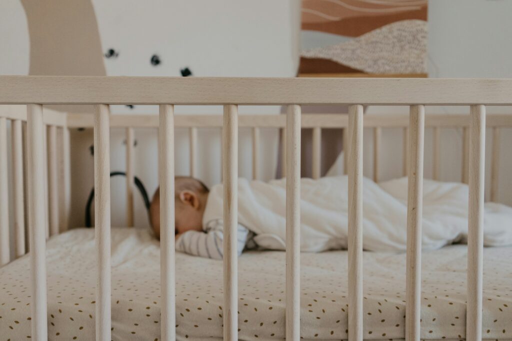 Newborn sleeping peacefully on the best crib mattress in a cozy, safe nursery — promoting infant sleep safety and comfort.
