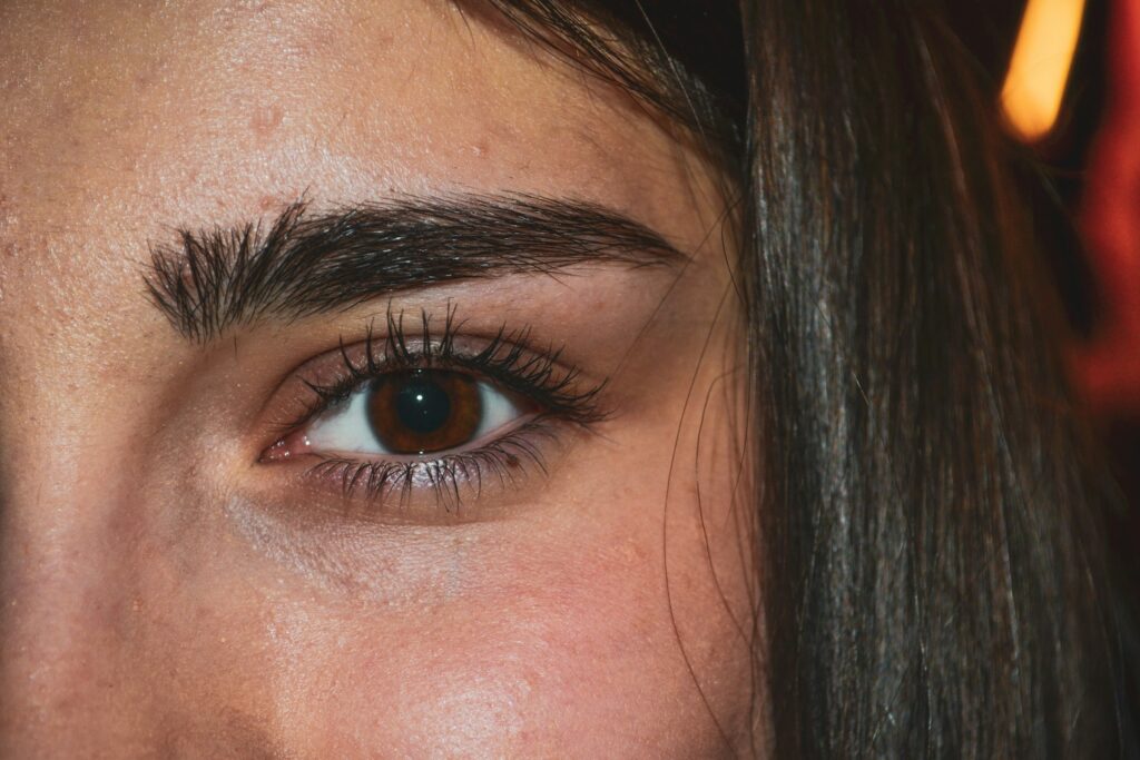 Woman with voluminous black hair and long lashes showcasing the beauty of eyelash and hair extensions.