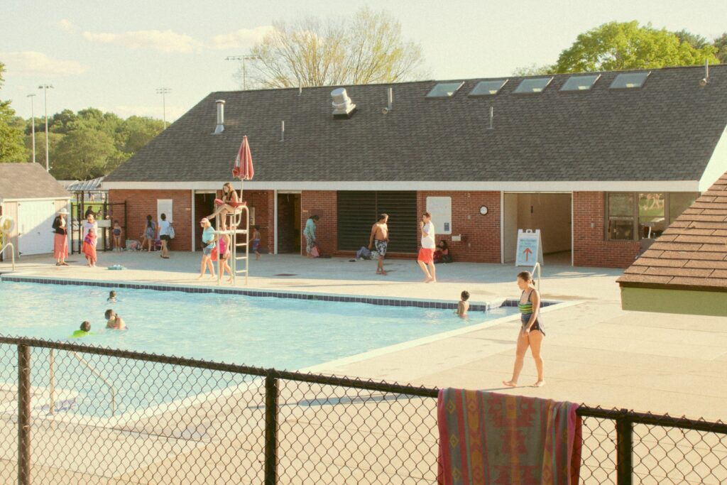 Families and children swimming at outdoor recreation centers, highlighting community wellness and active living.