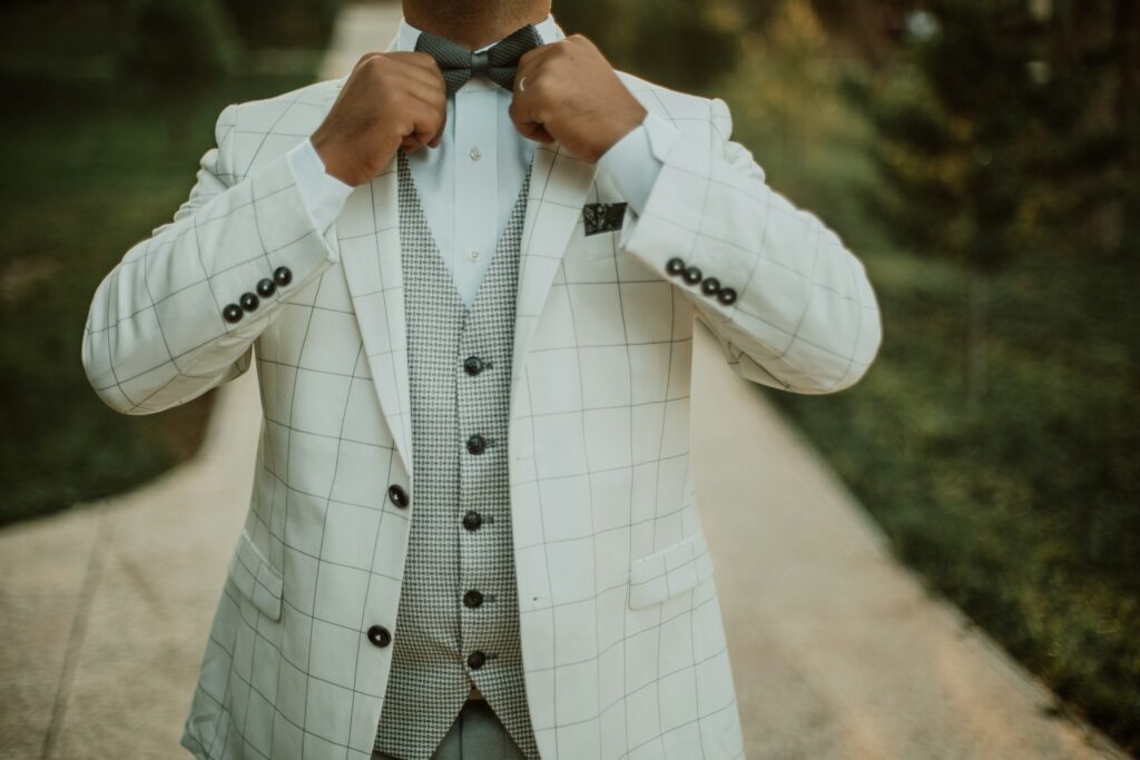 Man wearing a tailored white suit jacket, illustrating the tuxedo vs suit style comparison.