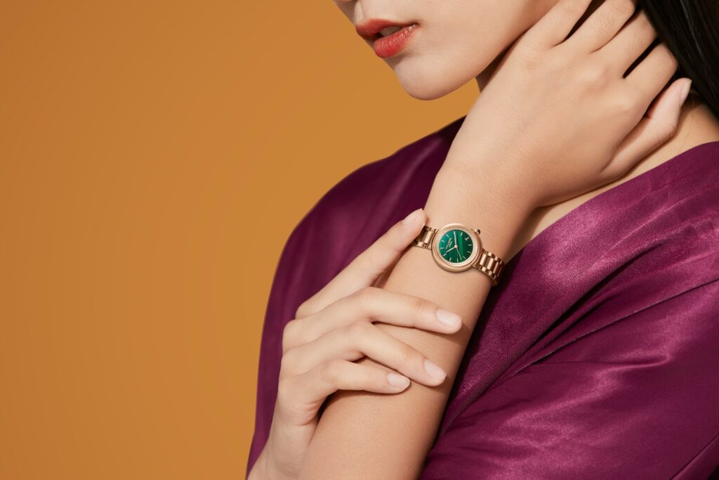 Woman wearing a gold wristwatch — minimalist and elegant accessory style, perfect for Coach gold bracelet watch inspiration.