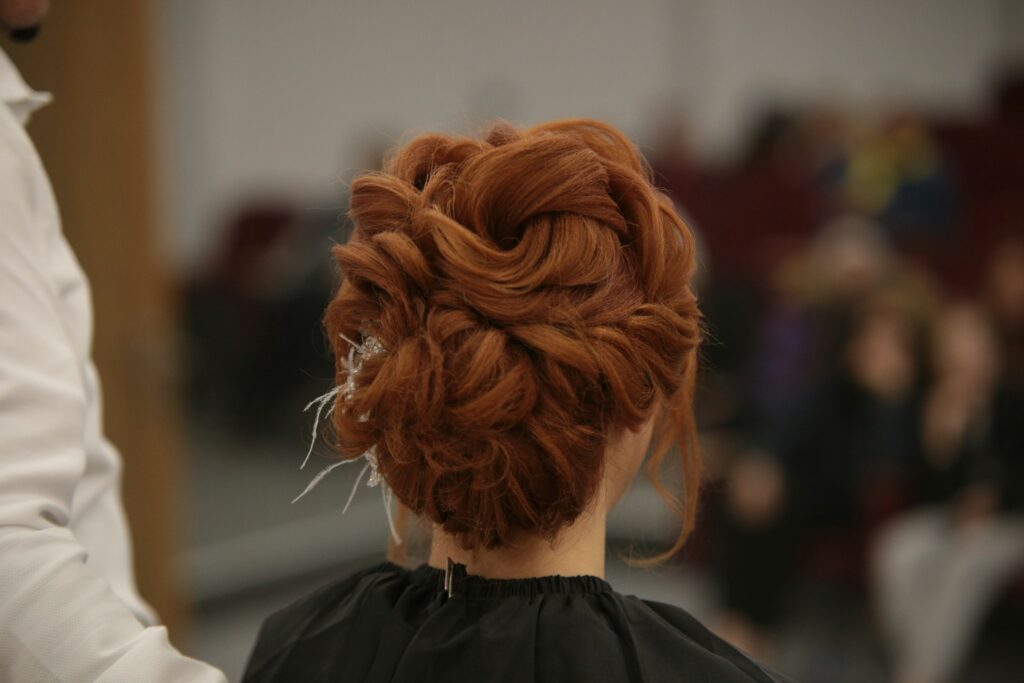 Elegant updo hairstyle for prom night showcasing 2025 prom hair trends with rich red hair and delicate accessories.