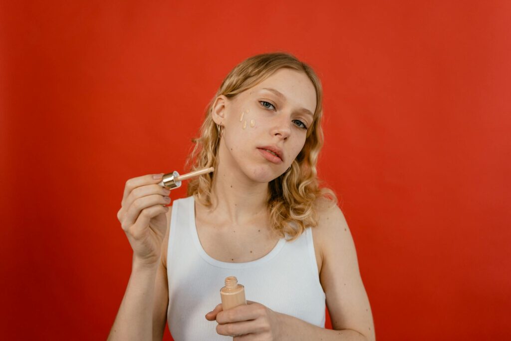 Woman applying tinted moisturizer for hydrated, glowing skin.