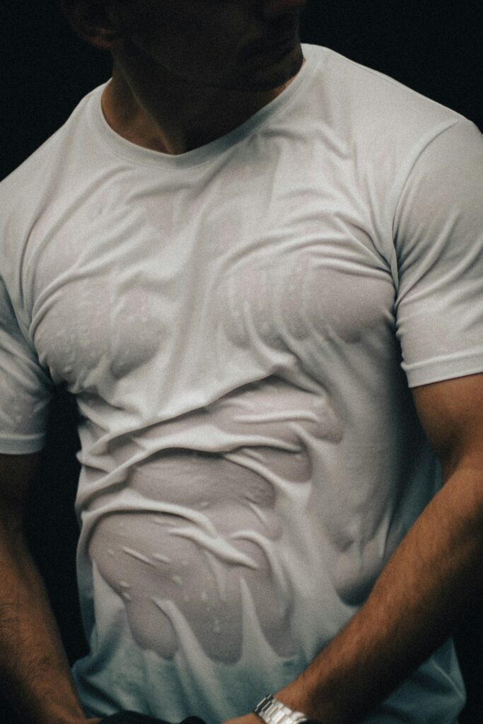 Man wearing a fitted white compression shirt showing defined muscle tone – best compression shirts 2025.