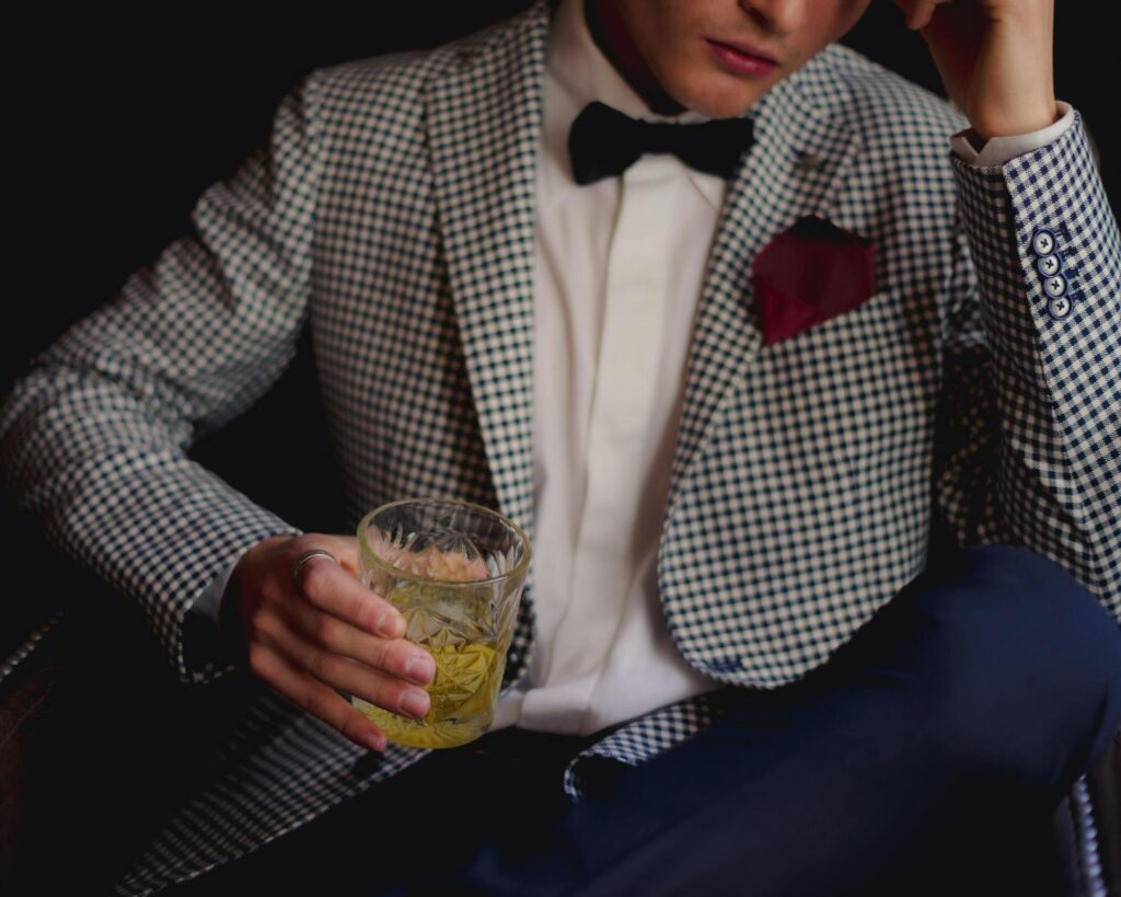 Man wearing a stylish seersucker suit with a bow tie and pocket square for elegant summer fashion.