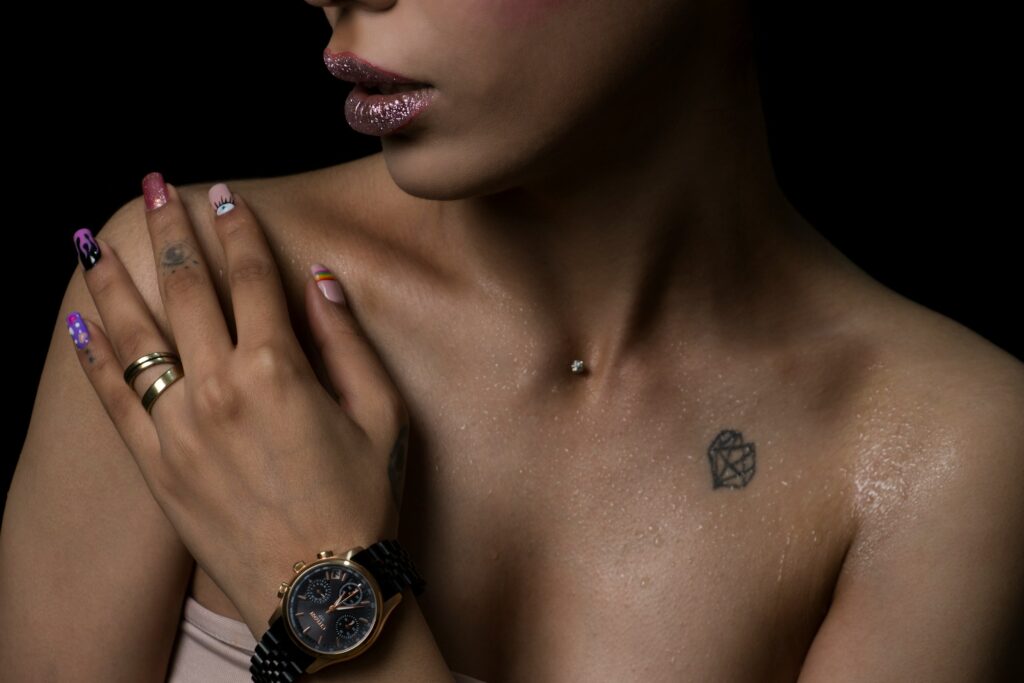 Close-up of a healed sternum dermal piercing with a small sparkling gem on a woman's chest.
