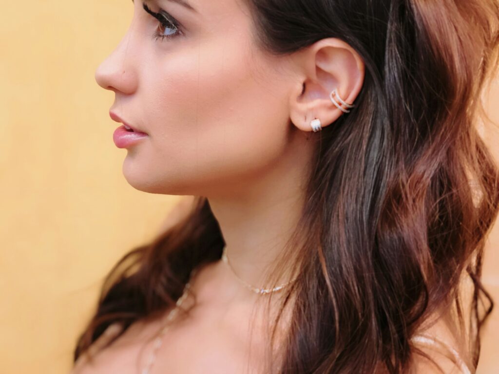 Woman with multiple ear piercings including helix and lobe stack showcasing types of ear piercings