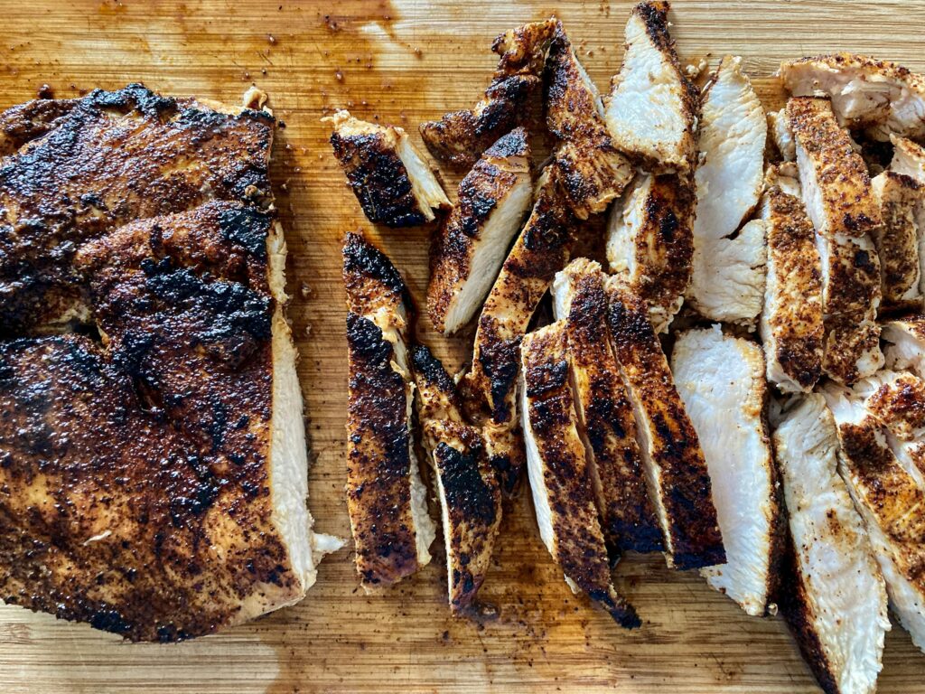 Sliced blackened Cajun chicken breast on a cutting board