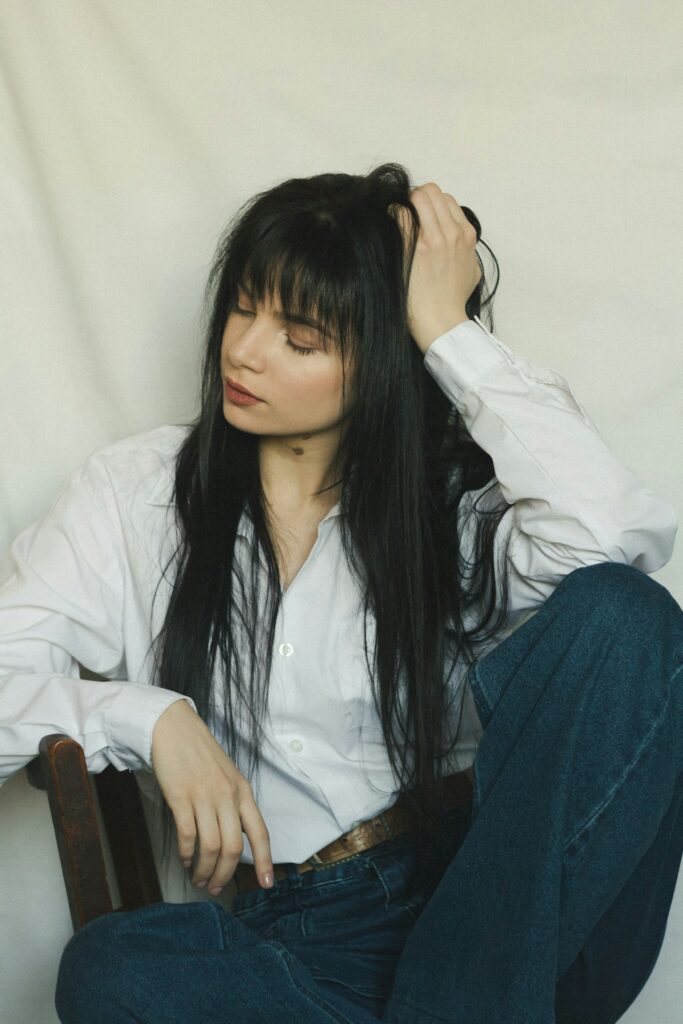 Long black hairstyle with soft curtain bangs framing the face for a chic everyday style.