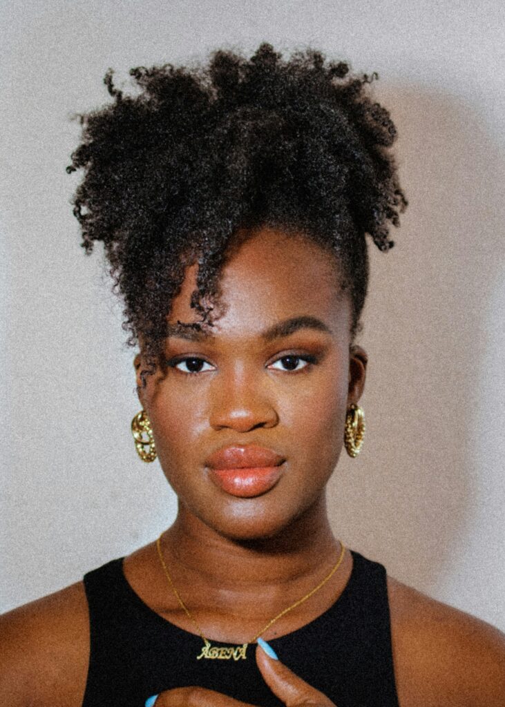 Natural high puff hairstyle for textured curly hair with defined edges and volume.