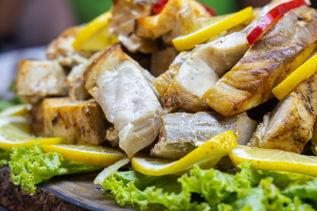 Grilled chicken souvlaki chunks with lemon slices and lettuce.