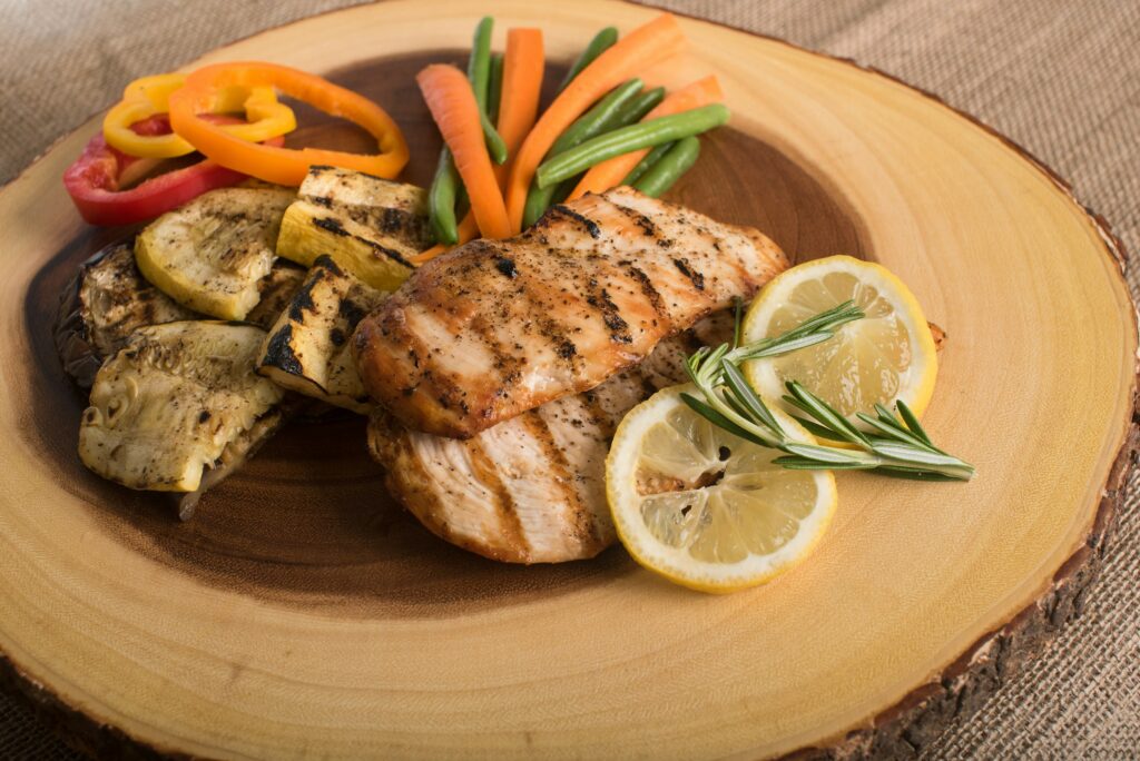 Grilled healthy chicken breast recipe with peppers, green beans, and lemon.
