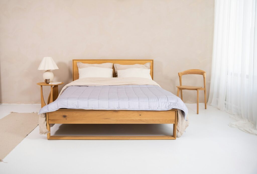 Solid oak wood bed frame with open box construction in a minimalist bedroom
