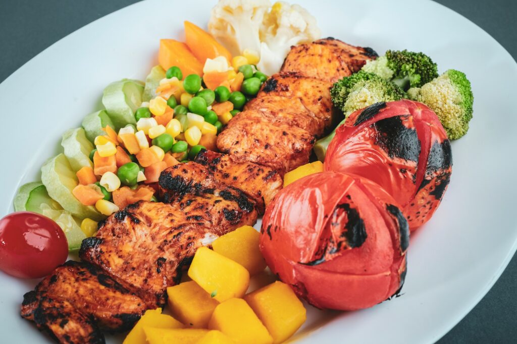 Spiced grilled chicken breast with charred tomato and roasted vegetables.