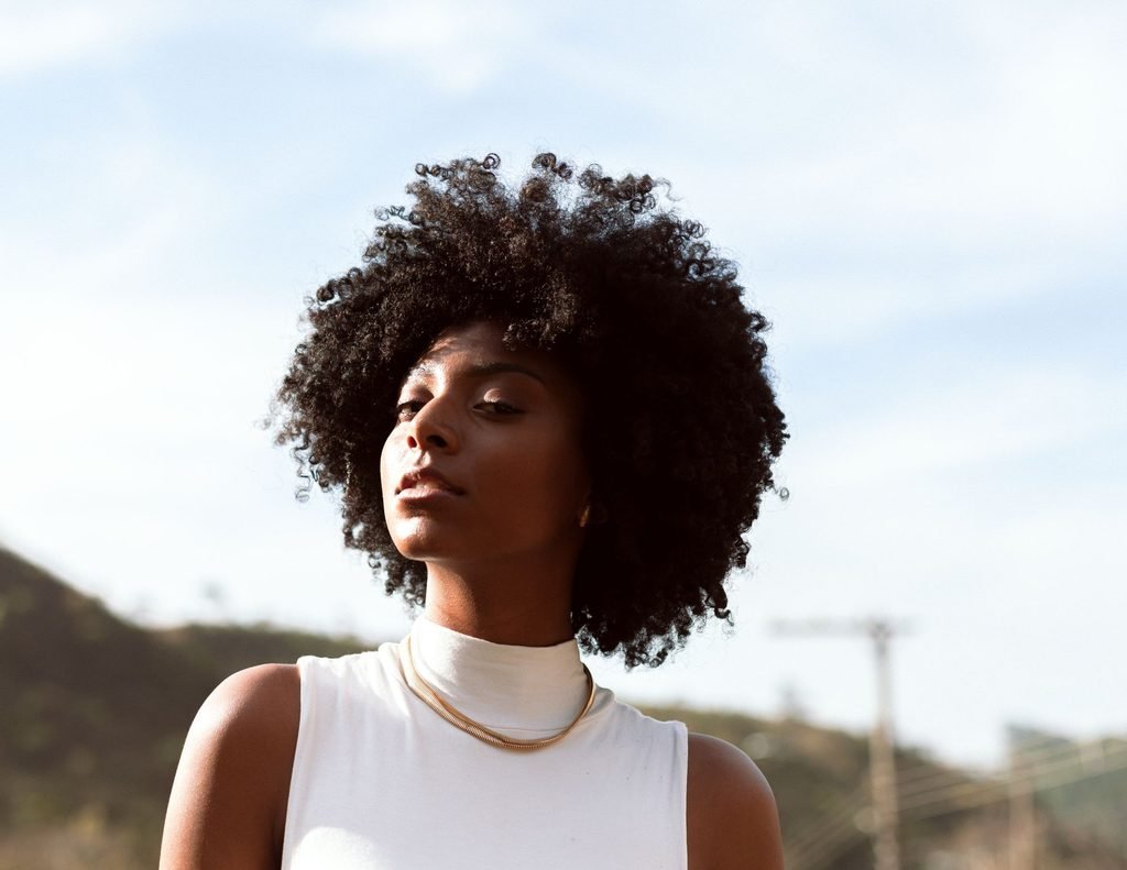 Woman with a voluminous 4C coily afro texture outdoors in natural light